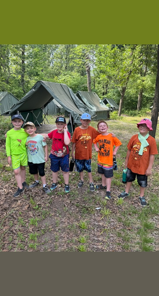 Bear Scouts posing in front of tents at camp